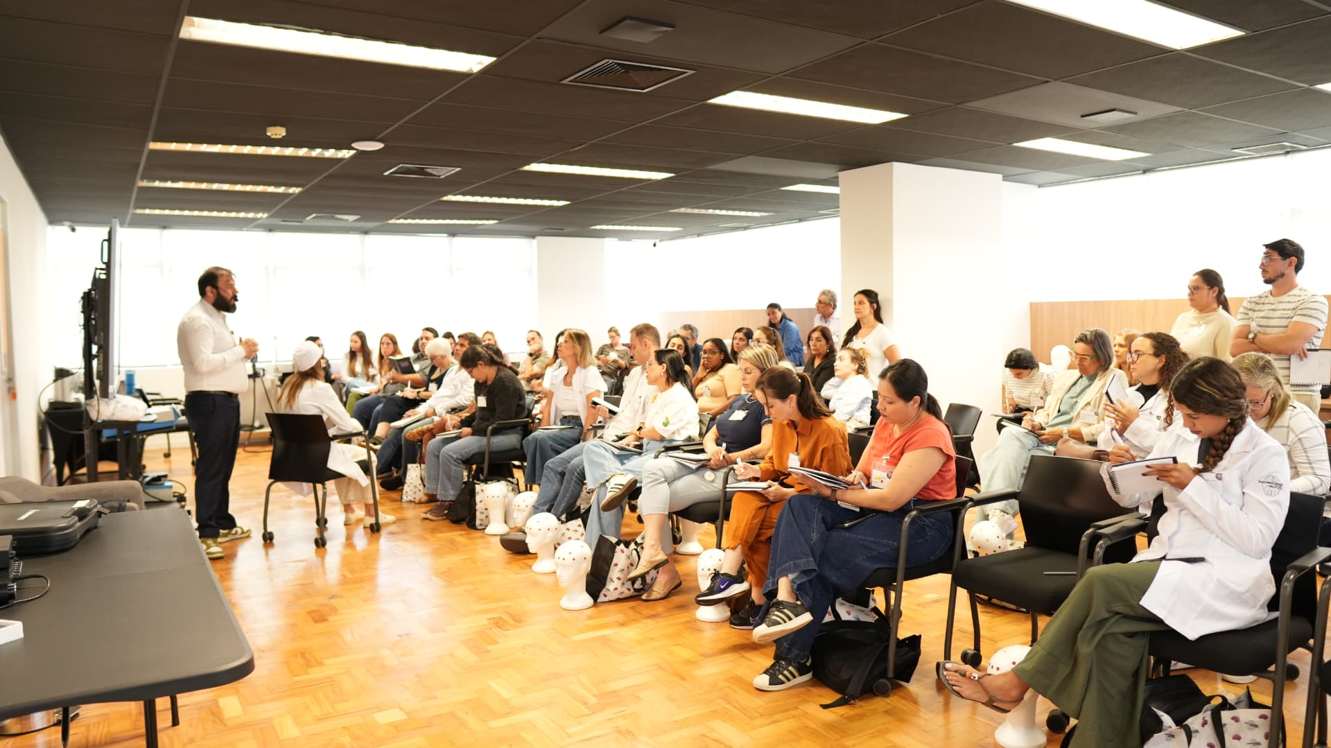 Turma de profissionais da saúde assistindo aula de neuromodulação